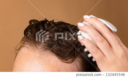 Scalp exfoliation with massage brush and foam during washing process 132845546