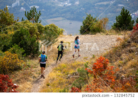 Group three athletes running mountain marathon in fall 132845752