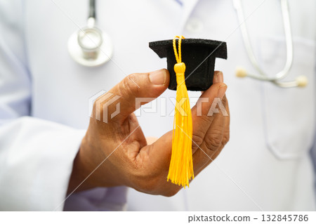 Asian woman doctor holding graduation hat in hospital, Medical education. Asian woman doctor holding graduation hat in hospital, Medical education. 132845786