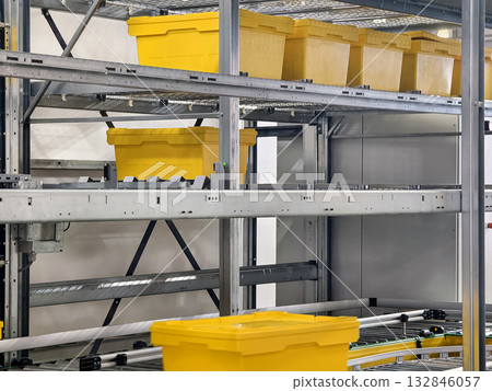 Yellow storage containers arranged on shelves in a warehouse for efficient organization and inventory management 132846057