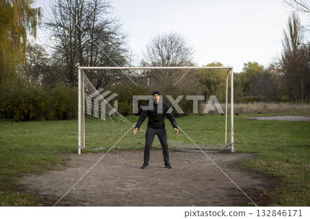 A goalkeeper with a torn net on an outdoor sports ground 132846171