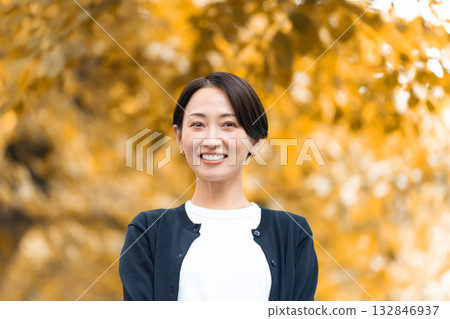 一個女人在秋天的公園散步 132846937