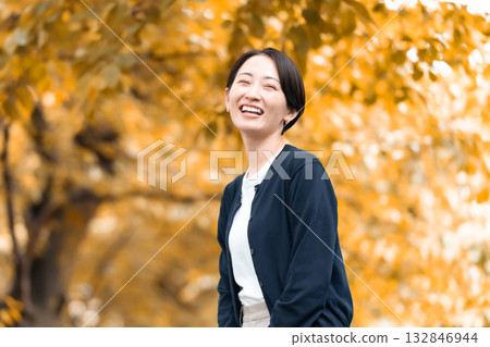 一個女人在秋天的公園散步 132846944