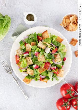 Lebanese fattoush salad with fresh vegetables, romaine lettuce and pita bread on white background. Top view. Lebanese fattoush salad with fresh vegetables, romaine lettuce and pita bread on white background. Top view. 132847179