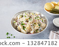 Potato salad with pickled cucumbers and onions on gray background. Copy space. German, American cuisine. 132847182
