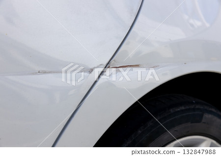 Dents near the rear door of a car Dents near the rear door of a car 132847988