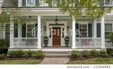 Elegant home exterior with a welcoming front porch and beautiful landscaping 132848464