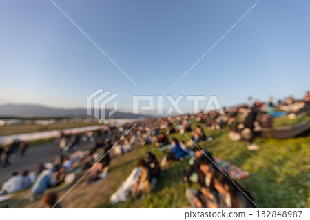 一張許多人坐在河岸上的照片（失焦）。鄉村活動場地 132848987