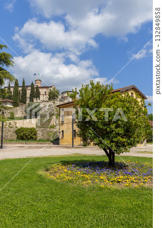 View of Brescia Castle from Piazzale della Locomotiva framed by green lawn and warm sunlight glow View of Brescia Castle from Piazzale della Locomotiva framed by green lawn and warm sunlight glow 132849858