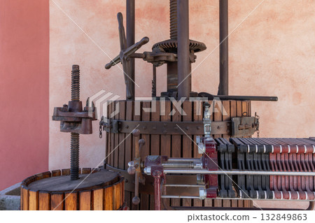 Old olive oil press made of wood and metal featuring large screw and gear mechanisms for pressing Old olive oil press made of wood and metal featuring large screw and gear mechanisms for pressing 132849863