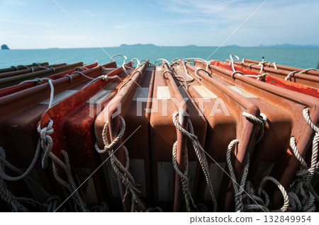 Lifebuoys arranged on ship deck with ocean view and blue sky on sunny day, maritime safety concept Lifebuoys arranged on ship deck with ocean view and blue sky on sunny day, maritime safety concept 132849954
