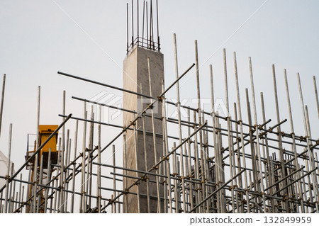 Vertical concrete column and scaffolding structure on industrial construction site outdoors 132849959