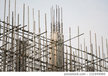 Concrete pillar with metal scaffolding structure on building site during construction phase 132849960