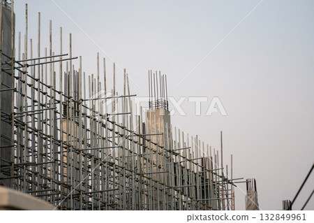 Steel scaffolding and concrete columns on construction site under clear sky at daylight 132849961