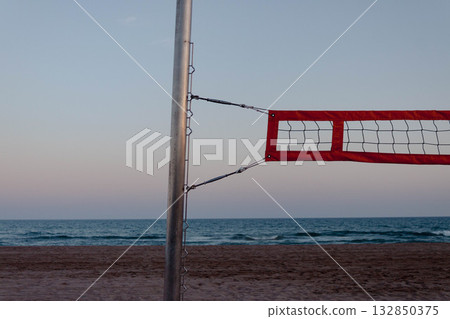 Beach volleyball net with red border at sunset near the sea Beach volleyball net with red border at sunset near the sea 132850375