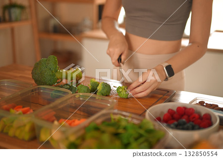 cropped shot woman preparing fresh broccoli and vegetables in her kitchen cropped shot woman preparing fresh broccoli and vegetables in her kitchen 132850554