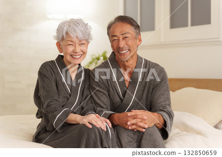 Senior couple wearing bathrobes in the bedroom (night) 132850659