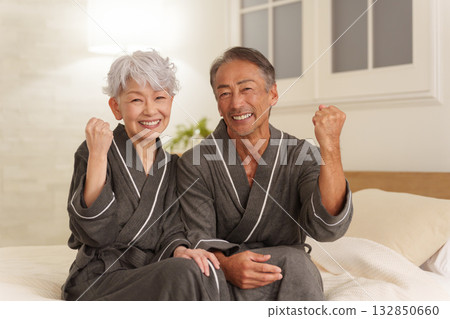 Senior couple wearing bathrobes in the bedroom (night) 132850660