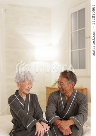 Senior couple wearing bathrobes in the bedroom (night) 132850663