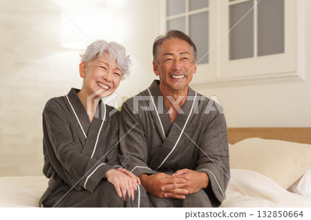 Senior couple wearing bathrobes in the bedroom (night) 132850664