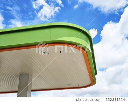 Gas station canopy against a blue sky with clouds. 132851314