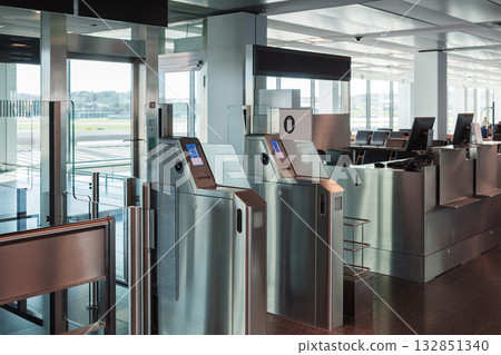 Automated airport gate at modern airport for scanning boarding pass. Concept of digitalization, self-check-in and independent travel. Automated airport gate at modern airport for scanning boarding pass. Concept of digitalization, self-check-in and independent travel. 132851340