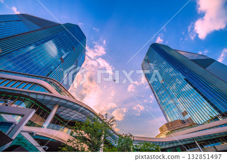Tokyo cityscape in Japan. View of Takanawa Gateway City in front of Takanawa Gateway Station. Aircraft in the sky (E2 series) Tokyo cityscape in Japan. View of Takanawa Gateway City in front of Takanawa Gateway Station. Aircraft in the sky (E2 series) 132851497