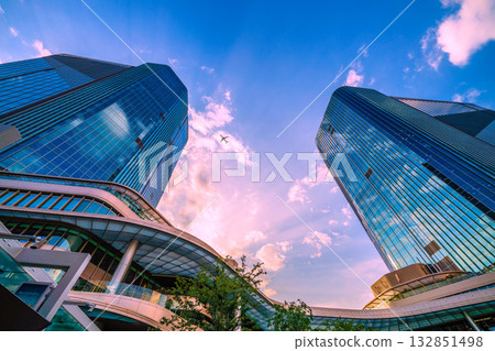 日本東京城市景觀。高輪Gateway站前的高輪Gateway City景觀。天空中的飛機（E2系列） 132851498