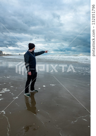 individual observes stormy seaside scenery, person stands silently watching approaching weather individual observes stormy seaside scenery, person stands silently watching approaching weather 132851796