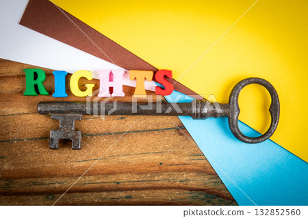 Creative symbolic image showing the word rights in colorful wooden letters beside an old vintage key 132852560