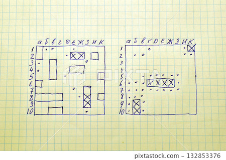 Several signs for the game "Sea Battle" are drawn with a pen on a piece of notebook paper in a grid. 132853376