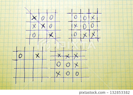 On a notebook sheet with checkered paper, several tic-tac-toe game signs are drawn with a pen. On a notebook sheet with checkered paper, several tic-tac-toe game signs are drawn with a pen. 132853382