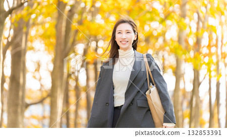 Autumn leaves of roadside trees and women/businesswomen 132853391