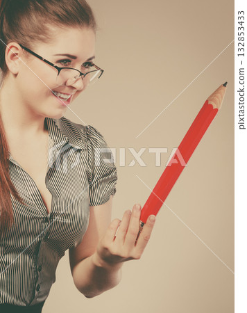 Teacher looking elegant woman holding big pencil 132853433