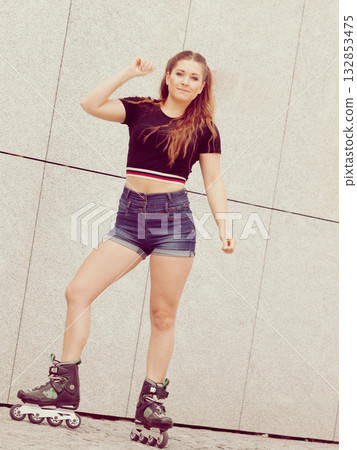 Young woman riding roller skates Young woman riding roller skates 132853475