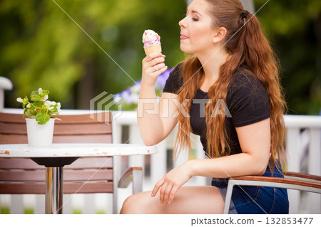 Young woman eating ice cream 132853477
