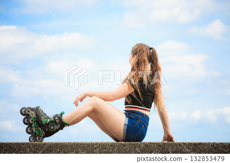 Happy young woman wearing roller skates Happy young woman wearing roller skates 132853479