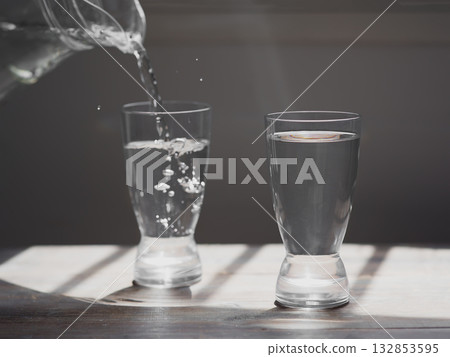 Glass of water on a wooden table Glass of water on a wooden table 132853595