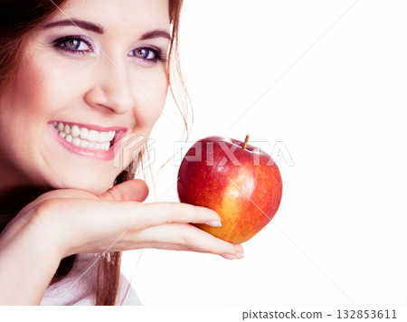 Woman holds apple fruit close to face, isolated Woman holds apple fruit close to face, isolated 132853611