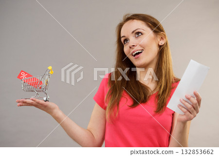 Woman with bill and shopping cart 132853662