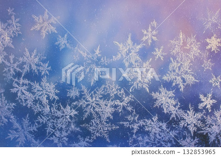Frosty Winter Snowflakes on Glass Against Blue Sky 132853965