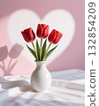 Red tulips in white vase on table Valentines Day. 132854209