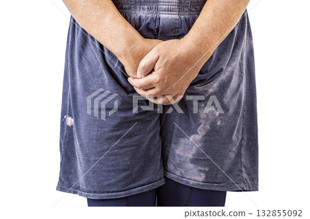 Person wearing blue shorts is standing with hands clasped in front of their crotch, conveying discomfort. Person wearing blue shorts is standing with hands clasped in front of their crotch, conveying discomfort. 132855092