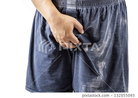 Person wearing dark shorts is standing and holding their crotch with one hand, possibly indicating discomfort. 132855093