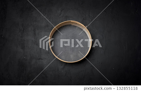 A round kitchen strainer with a wooden rim and fine mesh 132855118