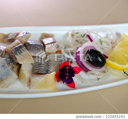 Marinated herring fillets with dill, onion rings, peppercorns and lemon isolated on white, top view Marinated herring fillets with dill, onion rings, peppercorns and lemon isolated on white, top view 132855243