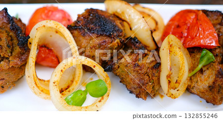 Kebabs grilled meat skewers, shish kebab with vegetables on a plate. On a concrete old table. Top view. 132855246