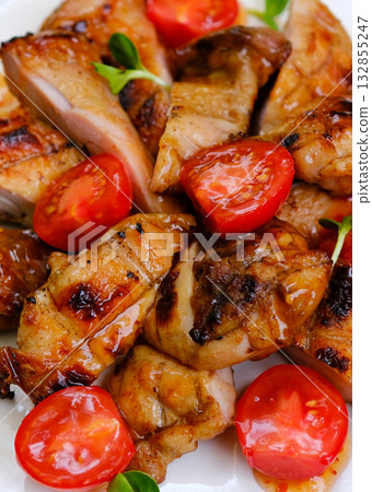 Grilled chicken breast fillet with lattuce salad and cherry tomatoes . Top view on rustic background Grilled chicken breast fillet with lattuce salad and cherry tomatoes . Top view on rustic background 132855247