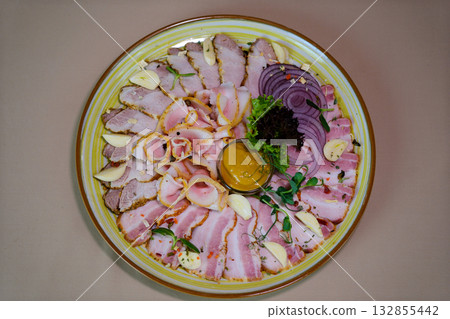 tray with assorted sliced meats garnished with green leaves, set in a banquet environment. Ideal for catering, hospitality, and food service themes. 132855442
