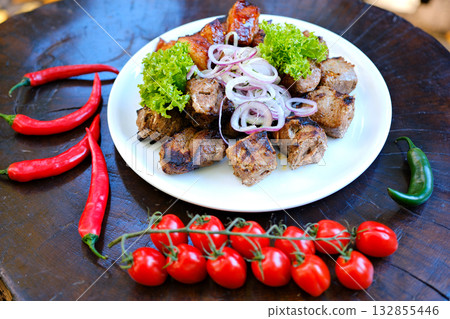 Grilled meat platter with ribeye steak, sausages, and tongue in bright natural light, overhead composition. Grilled meat platter with ribeye steak, sausages, and tongue in bright natural light, overhead composition. 132855446